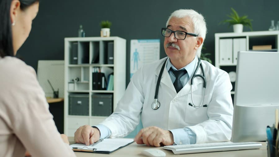 Médico atendiendo a una paciente en su consultorio